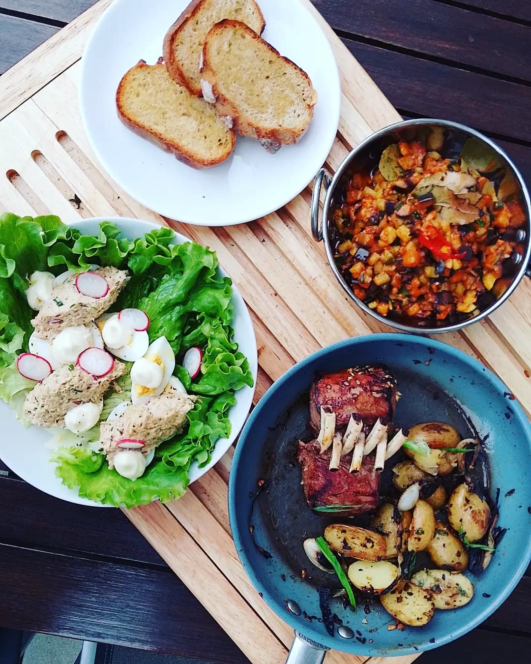 Table dressée avec rillettes, salade et pièce de bœuf grillée