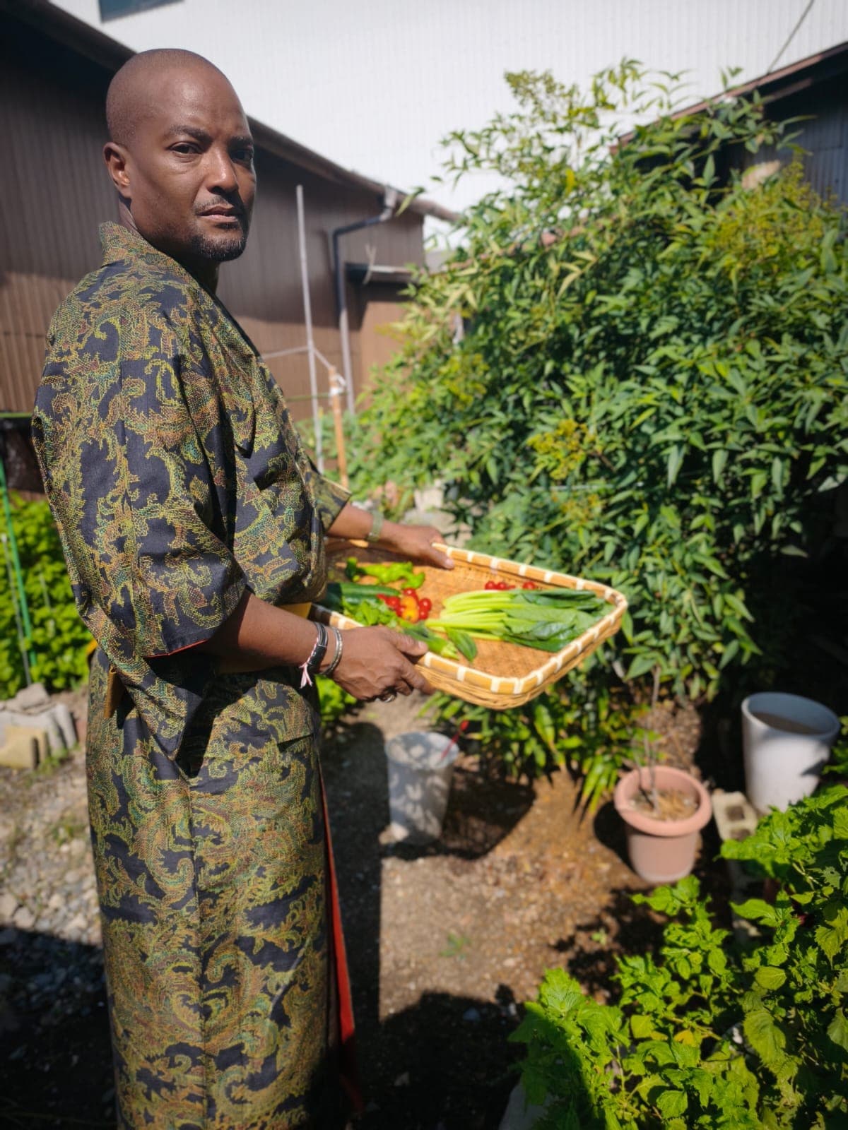 Rhonel en kimono, présentant un panier de légumes fraîchement récoltés